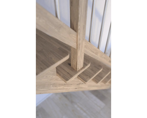Detailansicht einer Holztreppe mit Geländerstäben.