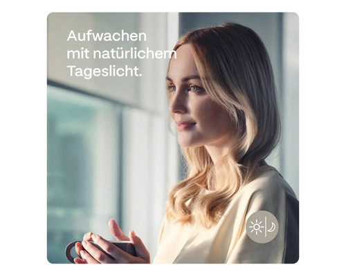 Frau mit Tasse vor einem Fenster mit Tageslicht