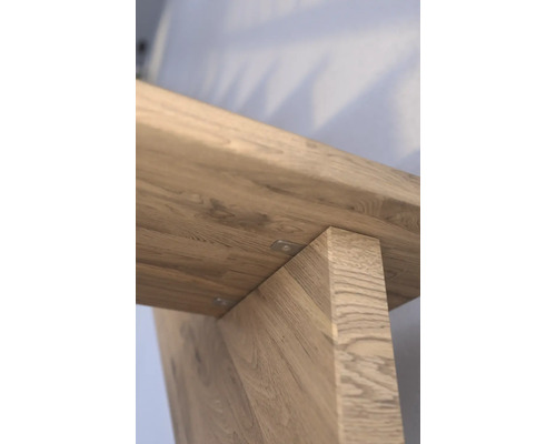 Detailansicht eines Holztisches mit Fokus auf die Tischbeine und die Holzmaserung