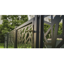 Metallzaun mit abstraktem Muster und Griff in einem Garten