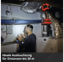 Ein Mann arbeitet im Heizungskeller unter dem Licht einer Einhell Akku-Handleuchte.