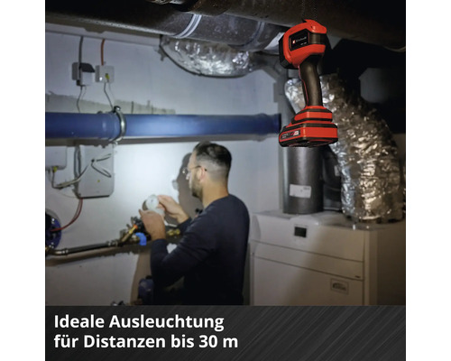 Ein Mann arbeitet im Heizungskeller unter dem Licht einer Einhell Akku-Handleuchte.