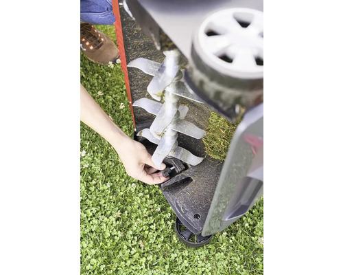 Ein Rasenlüfter mit Metallmessern wird auf einer Rasenfläche benutzt.