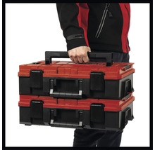 Zwei rote und schwarze Werkzeugkoffer werden von einer Person getragen.