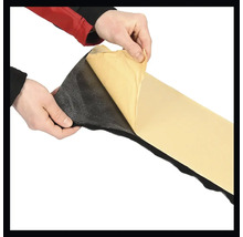 Hände ziehen die Schutzfolie von einer selbstklebenden Dämmmatte ab.