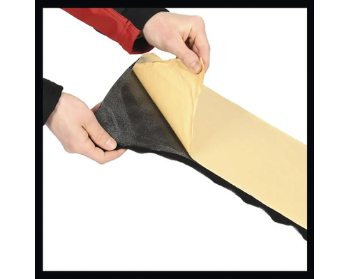 Hände ziehen die Schutzfolie von einer selbstklebenden Dämmmatte ab.