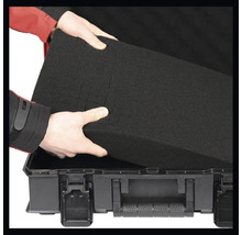 Person legt Schaumstoffeinlage in einen Werkzeugkoffer.