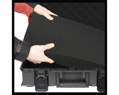 Person legt Schaumstoffeinlage in einen Werkzeugkoffer.