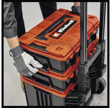 Einhell Werkzeugkoffer auf einem Rollwagen, mit Hand zum Öffnen eines Fachs.