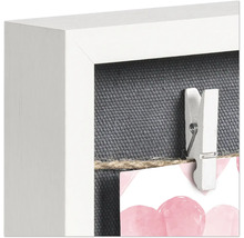 Detailansicht eines Bilderrahmens mit einer Wäscheklammer an einer Schnur