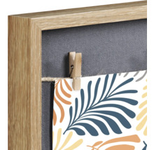 Detailansicht eines Memoboards mit Holzrahmen, Leinwand und kleiner Wäscheklammer