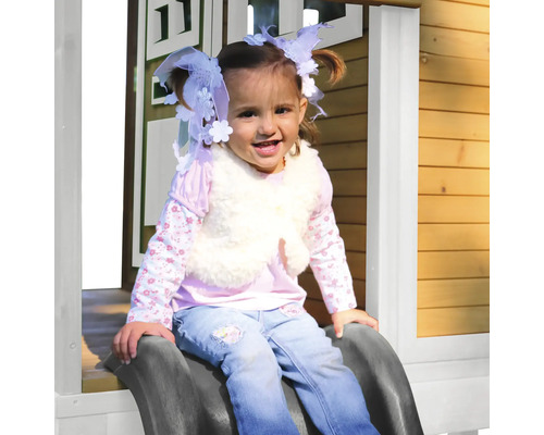 Mädchen rutscht auf einer Kinderrutsche in einem Spielhaus