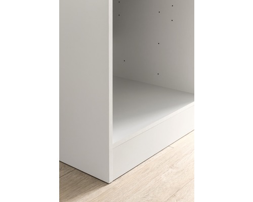 Detailaufnahme eines weißen Regals auf einem Holzboden.