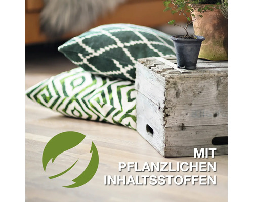 Dekorative Kissen mit Pflanzenmotiven neben einer Holzkiste und Pflanzen. Siegel: Mit pflanzlichen Inhaltsstoffen.