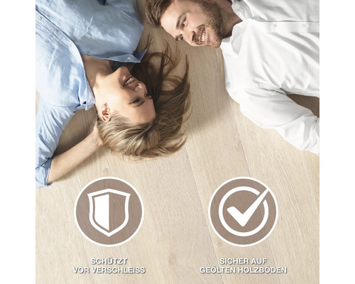 Paar liegt auf Holzboden mit Verschleißschutz-Symbol und sicher auf geölten Holzböden-Symbol