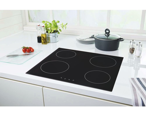Schwarzes Induktionskochfeld mit vier Kochzonen in einer hellen Küche.