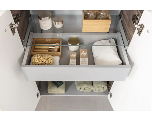 Offener Badezimmerunterschrank mit Kosmetikprodukten und Handtüchern