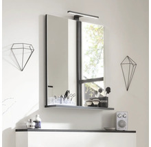 Badezimmer Spiegel mit Ablage und Lampe, ergänzt durch geometrische Dekorationen für einen modernen Look