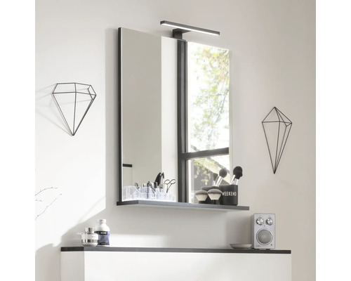 Badezimmer Spiegel mit Ablage und Lampe, ergänzt durch geometrische Dekorationen für einen modernen Look