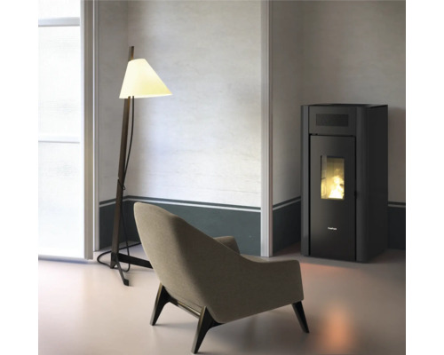 Wohnzimmer mit Sessel, Stehlampe und Pelletofen