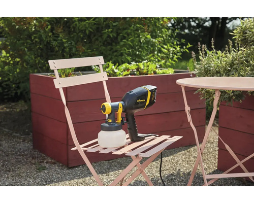 Wagner Farbsprühsystem auf einem Gartenstuhl neben einem Tisch und einem Hochbeet