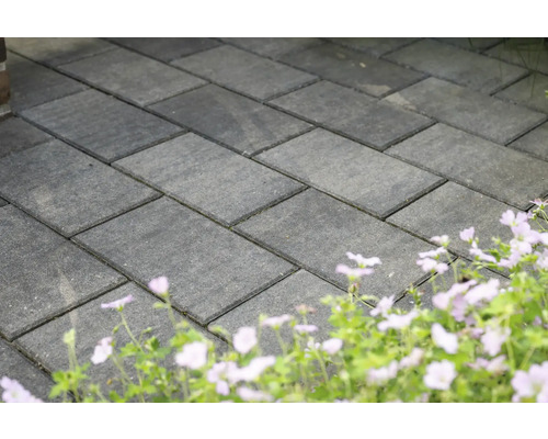 Verlegte Pflastersteine im Außenbereich mit Blumenbeet