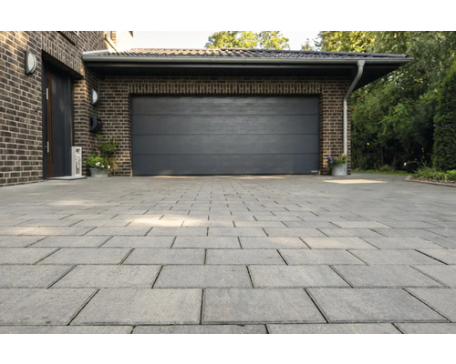 Einfahrt mit Pflastersteinen vor Garage und Haus