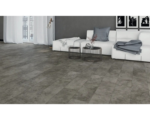 Wohnzimmer mit grauer Steinoptik-Bodenfliese, Couch, Tisch und Fenster für ein helles, modernes Ambiente.