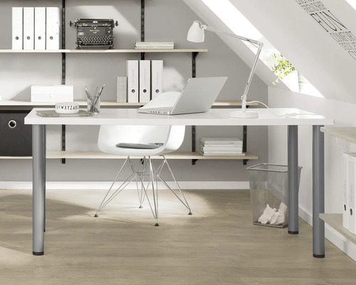 Arbeitszimmer mit Schreibtisch, Stuhl, Regalen und Büromaterialien in einem Dachgeschoss.