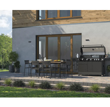 Terrasse mit Esstisch, Stühlen und Gasgrill vor einem Wohnhaus.