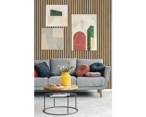 Wohnzimmer mit grauem Sofa, Kissen, Beistelltisch und abstrakten Wandbildern vor einer Wand mit Holzpaneelen