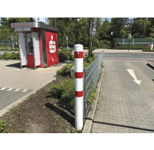Rot-weißer Sicherheitspoller neben einer Straße.