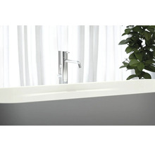 Freistehende Badewanne mit Armatur vor einem Fenster
