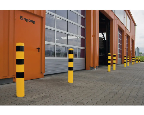 Eine Reihe von rammschutzpollern vor einem Gebäude mit Toren.