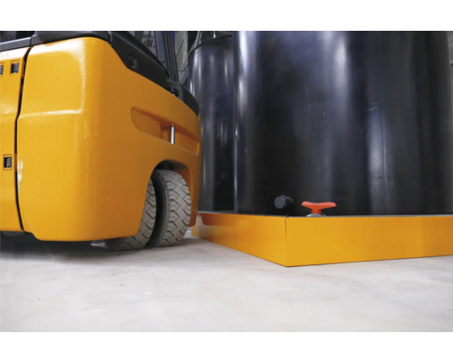 Gabelstapler neben einem schwarzen Tank mit Auffangwanne