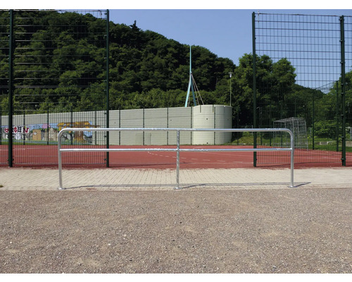 Außenansicht eines Bolzplatzes mit Metallzaun und Ballfangzaun.