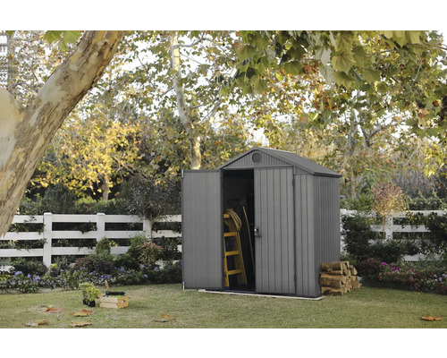 Gartenszene mit Gerätehaus, Leiter und Brennholz im Garten