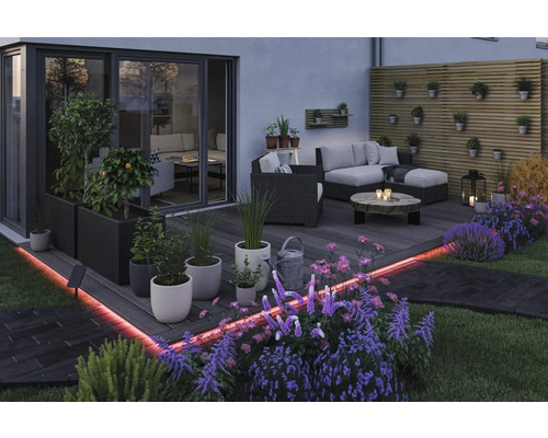 Gestalteter Terrassenbereich mit Sitzgelegenheiten, Pflanzen und LED-Beleuchtung für den Außenbereich.