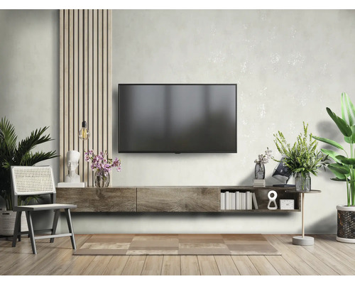 Wohnzimmer mit Fernseher, Lowboard, Stuhl und Dekoration für eine stilvolle Einrichtung.