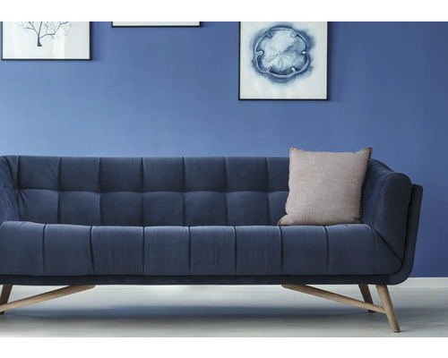 Blaues Sofa mit Kissen vor einer Wand mit Bildern