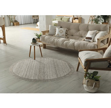 Wohnzimmer mit rundem Teppich, Sofa und Sessel aus Holz