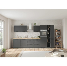 Moderne Küche mit grauen Schränken, Arbeitsplatte aus Holz und Edelstahlgeräten vor einer Wand mit Ziegelmuster.