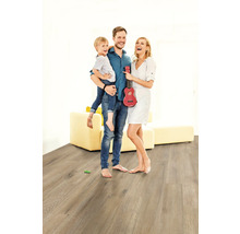 Familie mit Kind und Ukulele auf Laminatboden in einem hellen Wohnzimmer