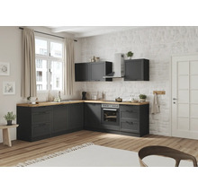 Moderne Küche mit grauen Schränken, Holzoberflächen und Geräten vor einer Ziegelwand.