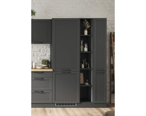 Dunkelgraue Küchenschränke mit Regalen und Schubladen vor einer weißen Steinwand.