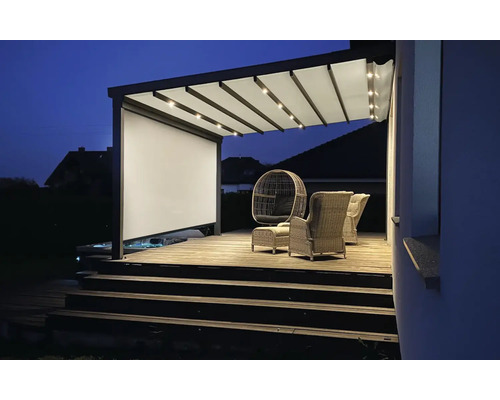 Terrasse mit Pergola, Beleuchtung und Sitzmöbeln am Abend