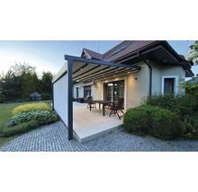 Terrasse mit Pergola, Tisch und Stühlen an einem Haus.