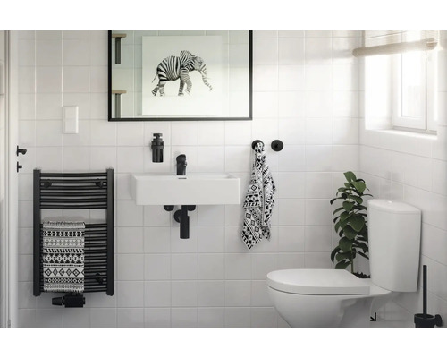 Helles Badezimmer mit Waschbecken, Handtuchwärmer und Toilette.