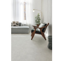 Helles Wohnzimmer mit Sofa, Sessel, Stehlampe und Zimmerpflanze