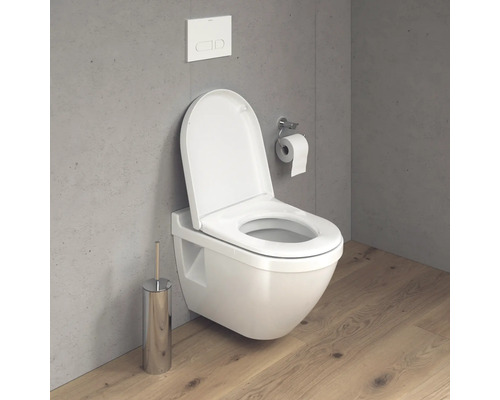 Wandhängendes WC mit offenem Spülrand und Toilettenbürste im Badezimmer.